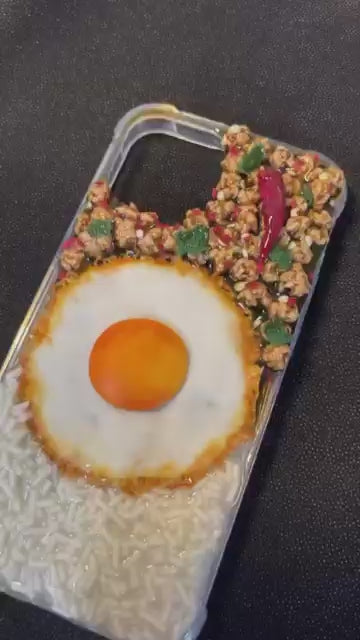 Realistische 3D-Handyhülle im Pad Kra Pao Streetfood-Design: Video zeigt die Herstellung eines einzigartigen Smartphone-Cases mit Reis, Thai-Basilikum und Spiegelei – lustige Geschenkidee für Foodies & Thailand-Fans.